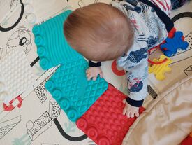 bébé qui s'amuse sur un tapis d'éveil