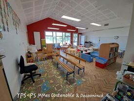Exemple d'une classe, avec des tables, chaises, bancs et lectures pour enfants.